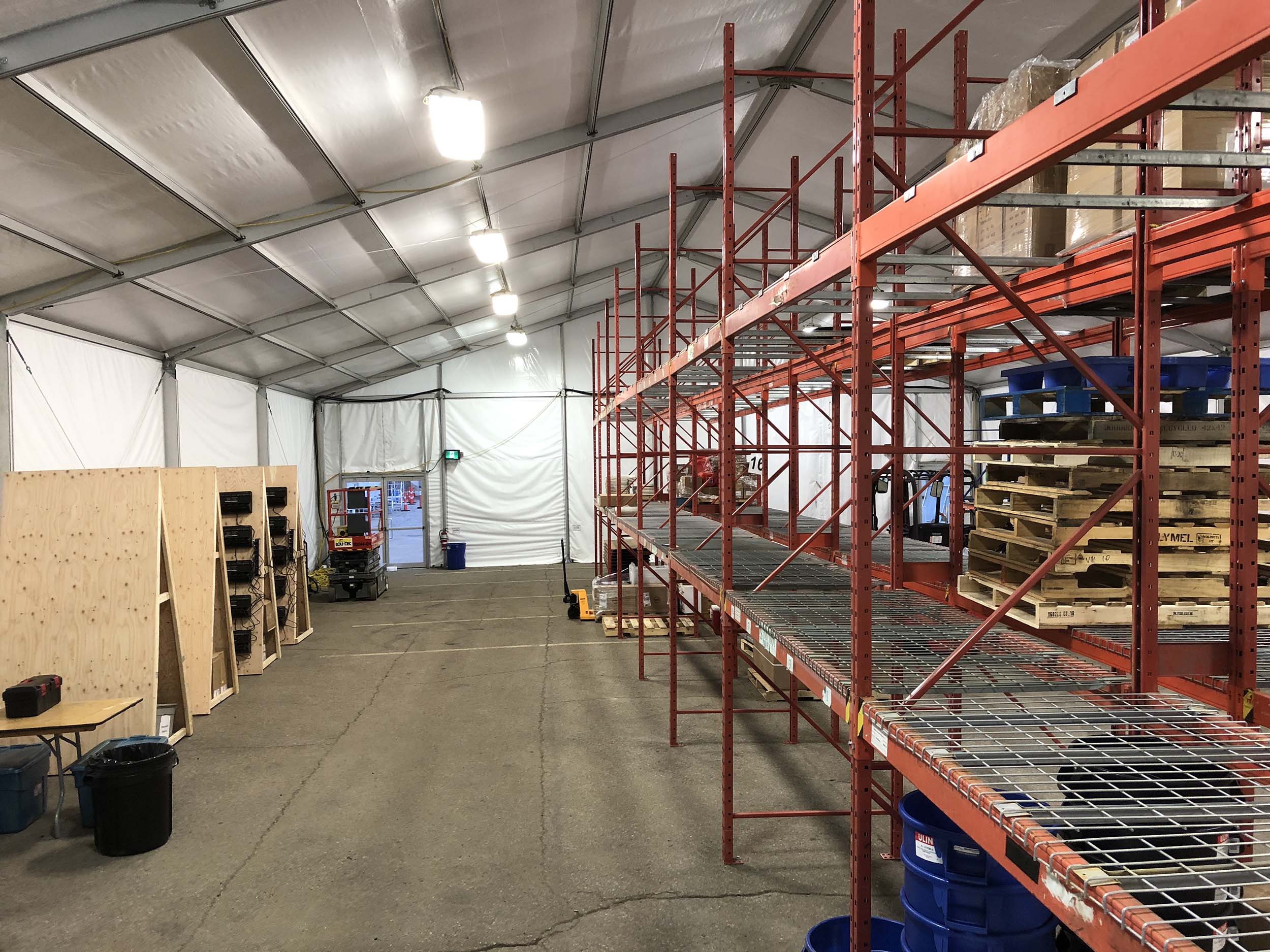 Temporary warehouse storage tent with large clearspan interior for manufacturing overflow inventory and raw material storage