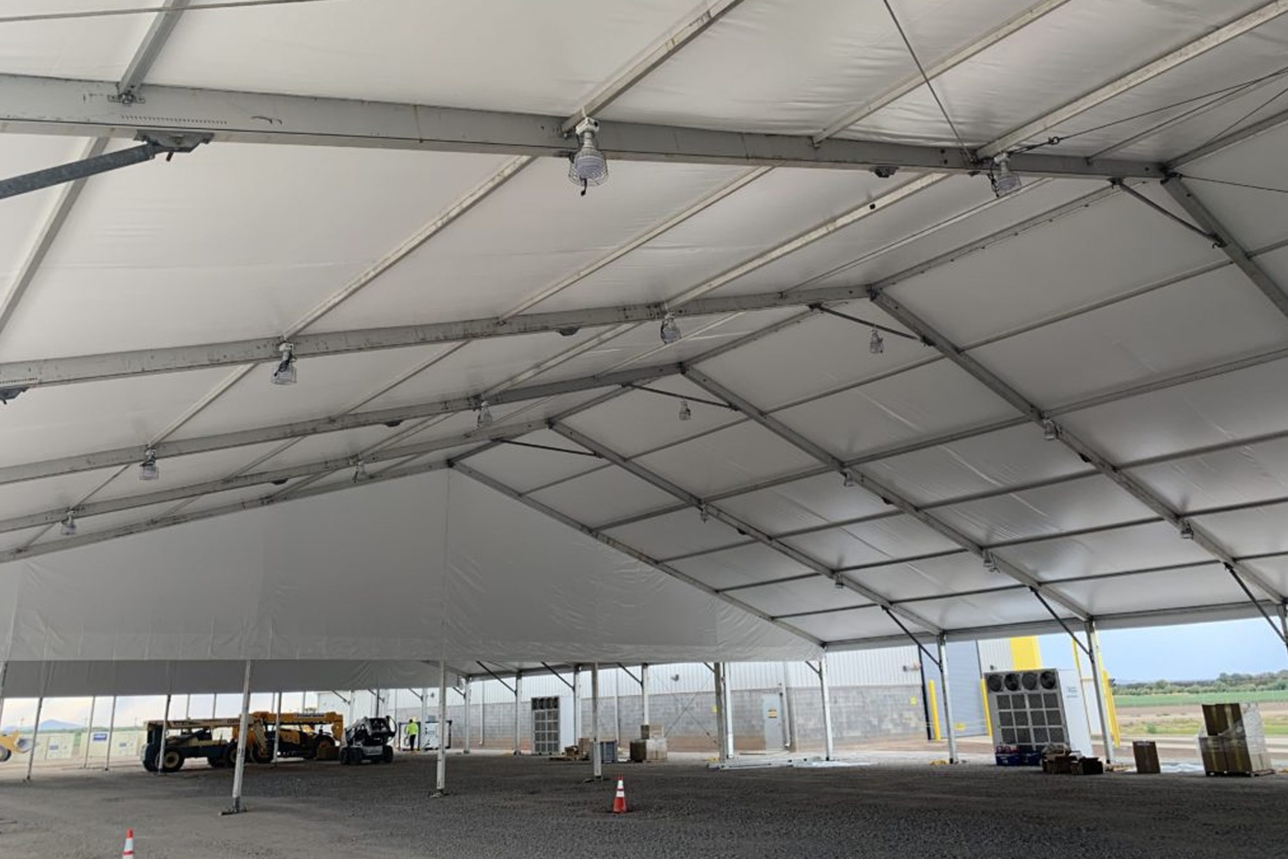 Large clearspan emergency response tent interior with aluminum frame, equipment staging, and open operations floor