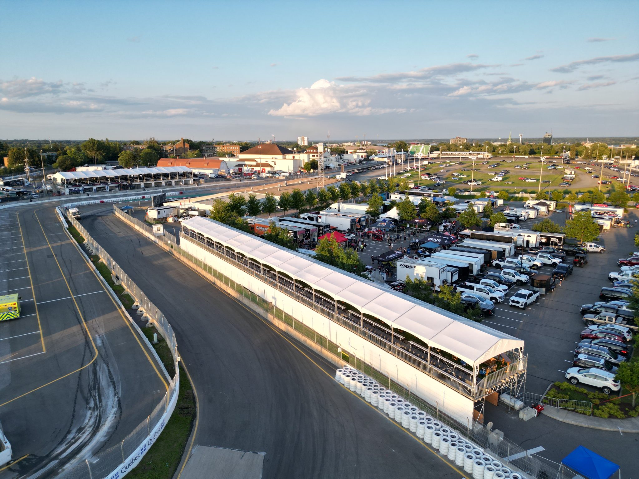 Multiple grand stand structure tents at racing venue with spectator viewing platforms and weather-resistant fabric covers