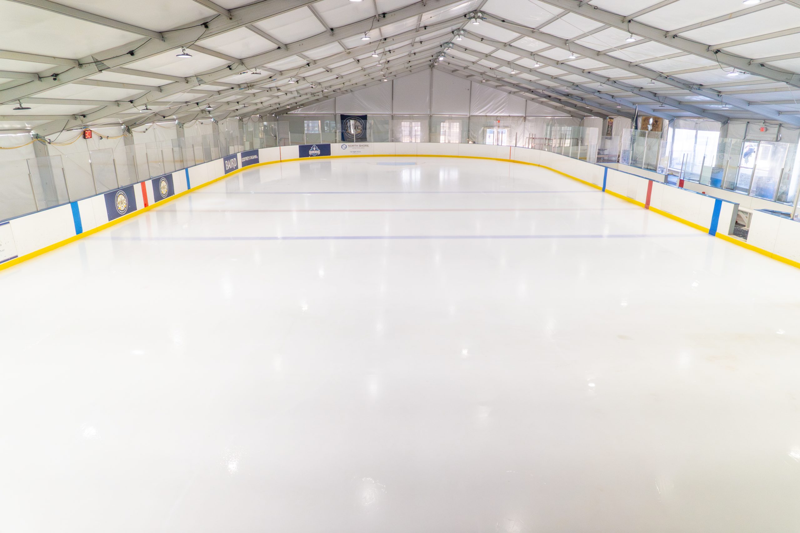 Ice Rink Inside Clearspan Structure — Sports Facility Full-size ice hockey rink inside clearspan fabric structure with boards, glass, lighting, and aluminum frame roof