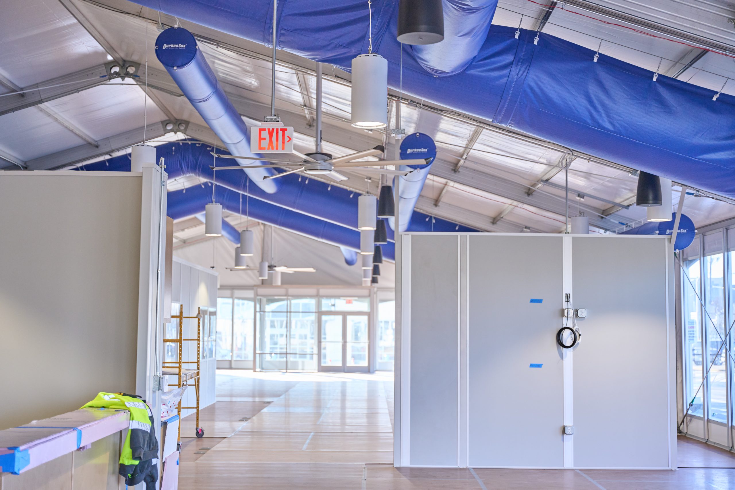 Temporary Office Interior — HVAC and Modular Partitions Interior of temporary office structure with blue HVAC ducting, modular wall partitions, pendant lighting, and commercial ceiling systems
