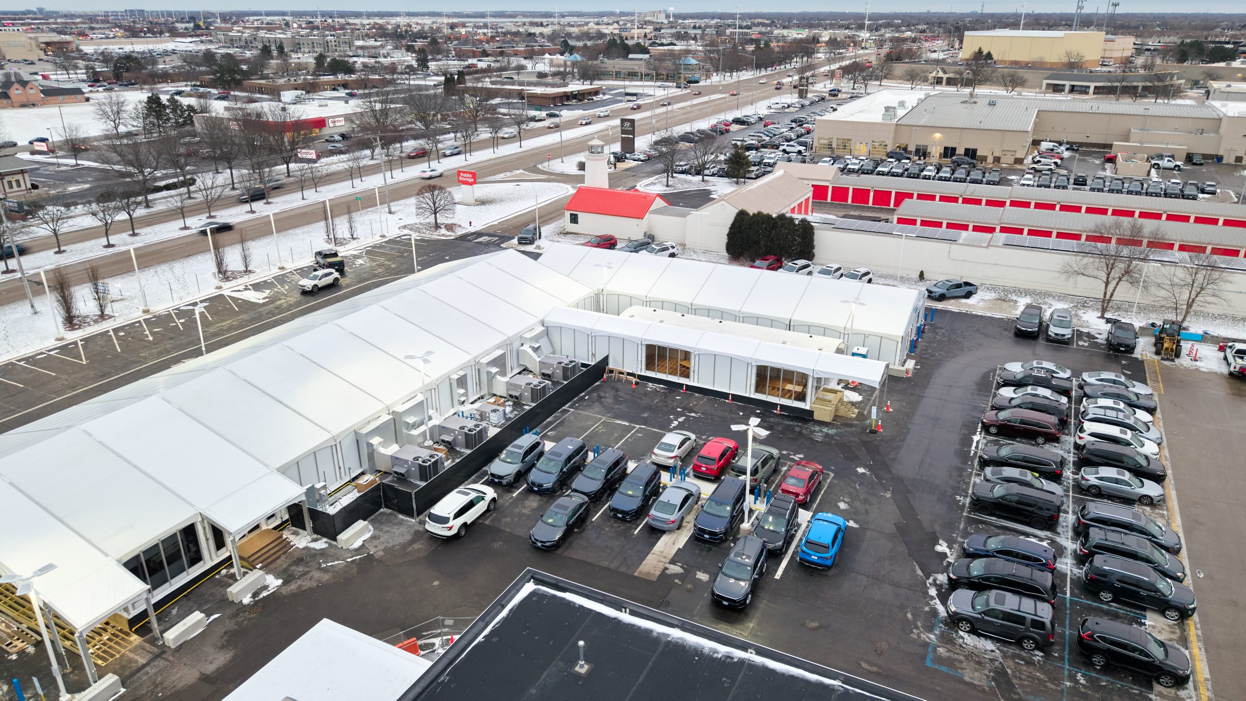 Business Continuity Campus — Aerial View of Office Complex Aerial view of temporary office building complex in commercial parking lot with glass walls, white fabric structure, and connected sections